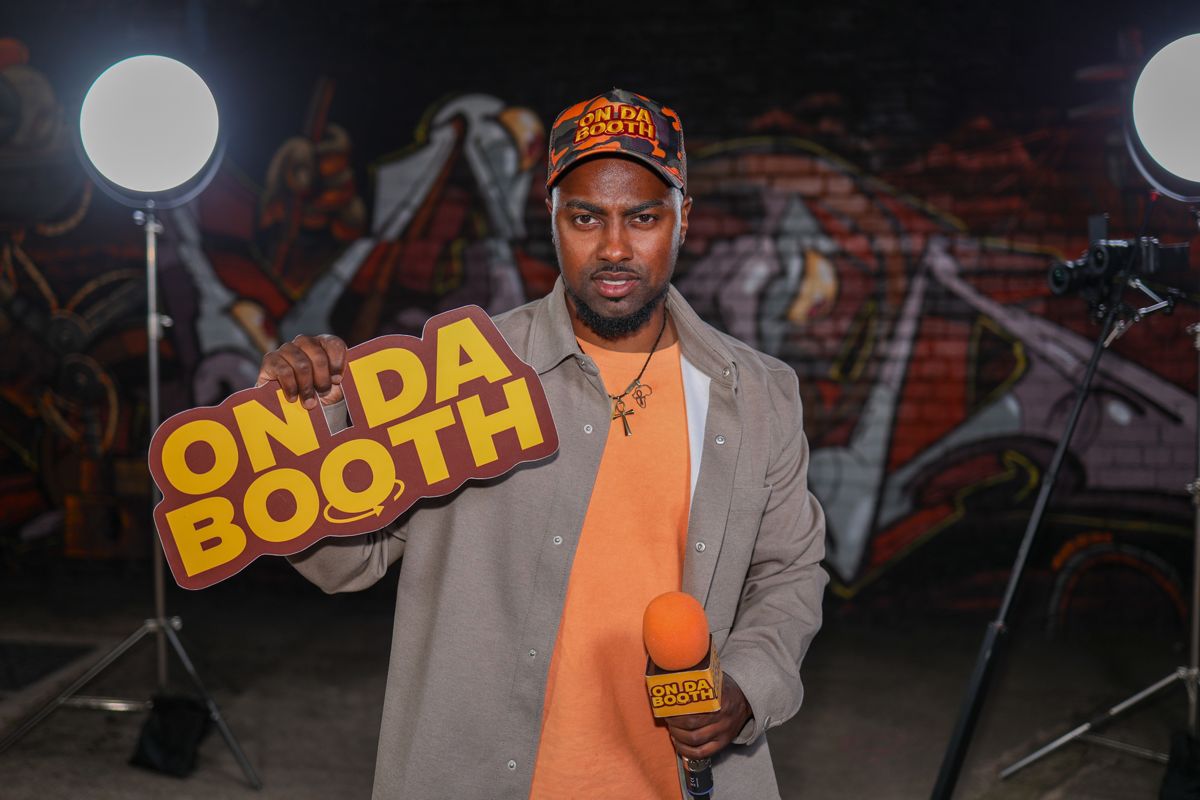 Da&rsquo;Rell with the On Da Booth sign and mic