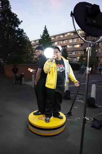 Two artists performing at dusk under the ring light